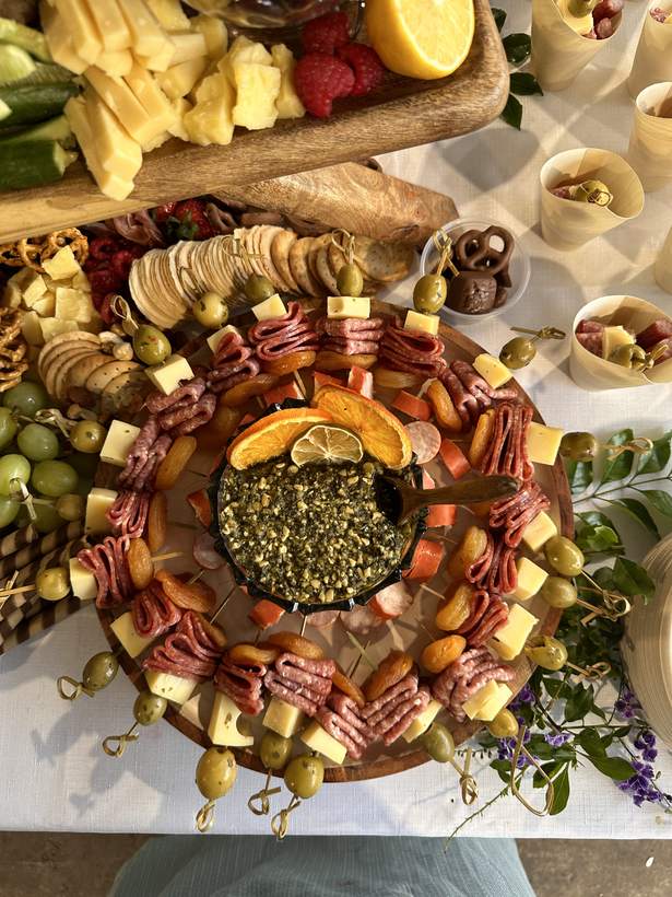 Skewers of salami and cheese around a bowl of pesto