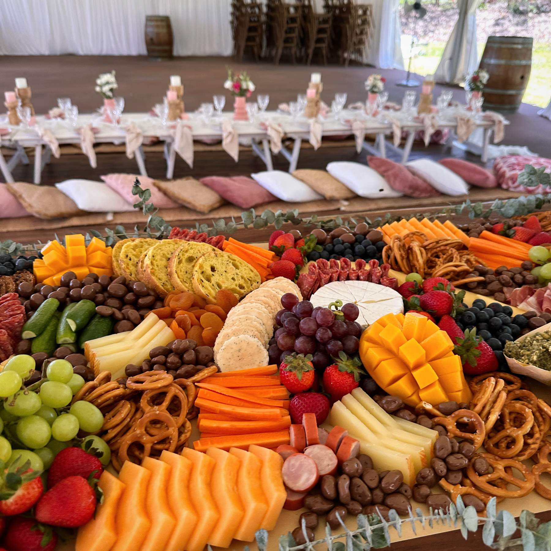 Grazing table close-up with rockmelon, mango, cheeses, pretzels and fresh fruit