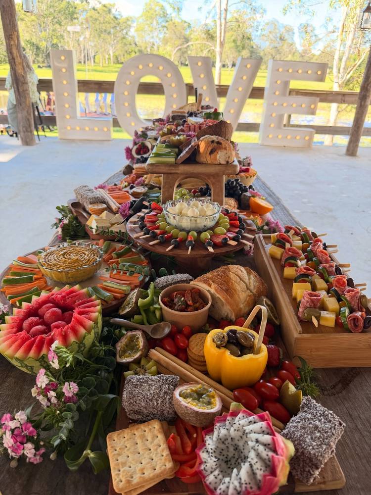 Grazing table in front of large LOVE letters at an outdoor venue