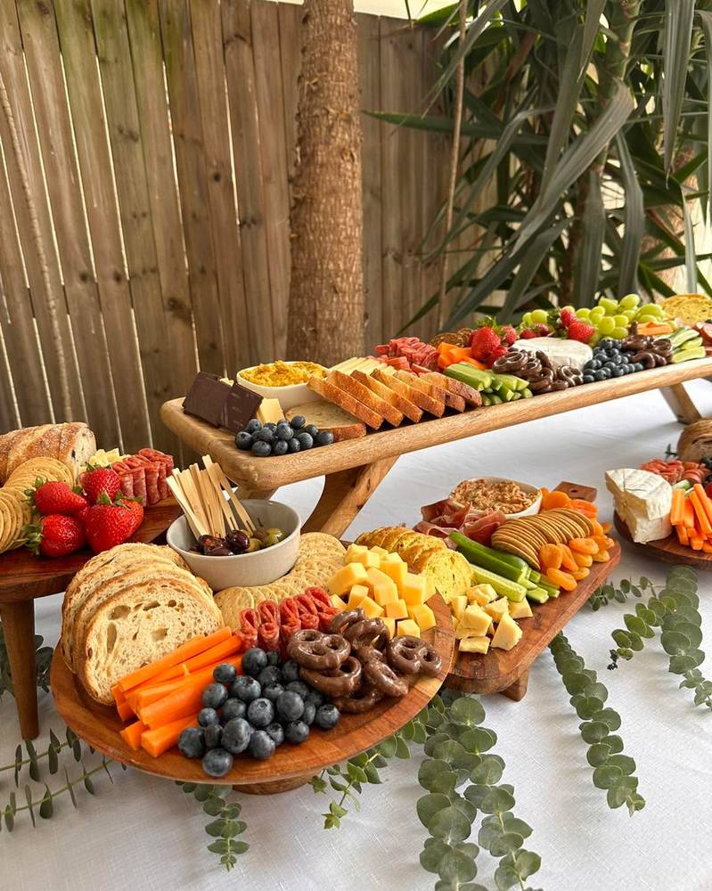 Tiered grazing table outdoors, with timber boards raised at different heights